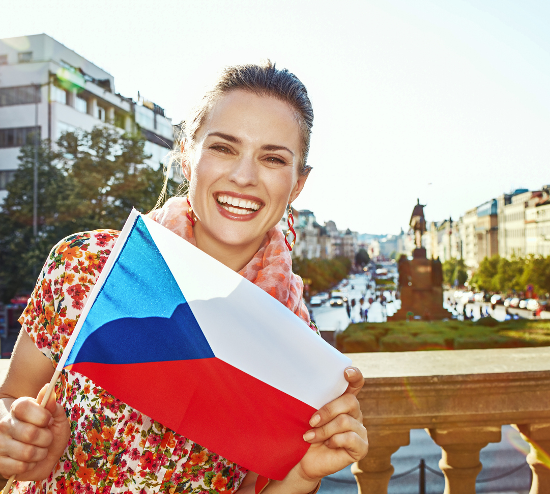 smiling woman on Vaclavske namesti in Prague showing flag