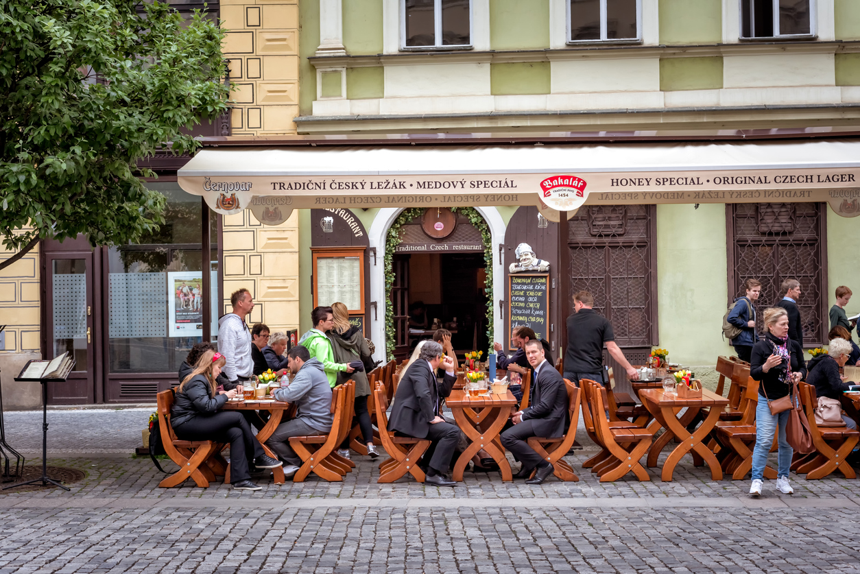 People have a lunch on Ovocny square in the Old Town of Prague