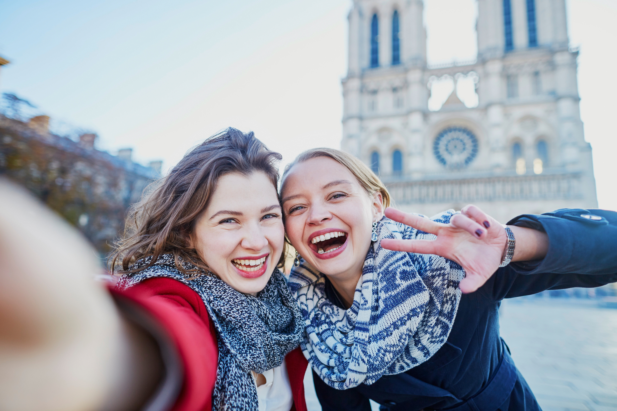 Two young girls taking selfie near Notre-Dame in Paris