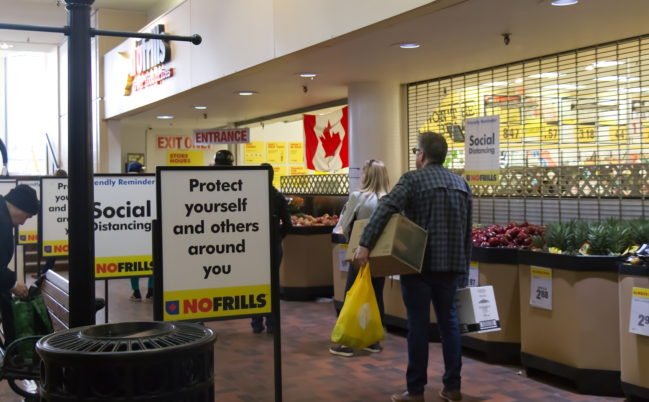 People are lining up to enter No Frills Store practicing social distancing between each other due to COVID-19.